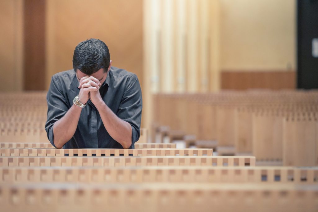 Young Beard Man Wearing Blue Shirt Praying In Modern Church – Cathedral 